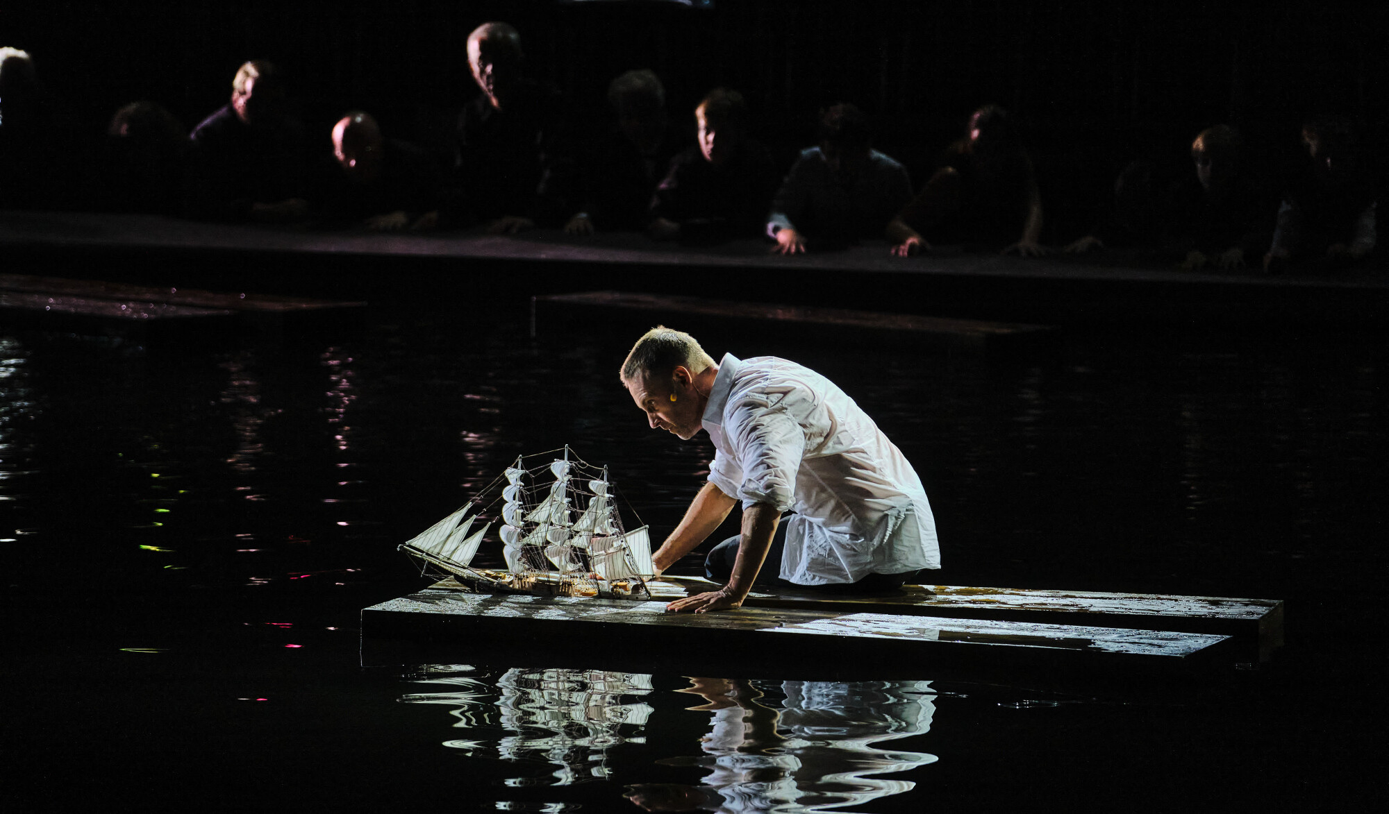 Bariton Günter Papendell sitzt im Wasser Holzsteg, vor ihm ein Schiffsmodell, Szene aus 